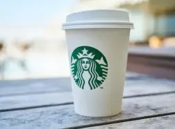 close up of takeaway Starbucks cup on wooden table - Intellectual Property and Protection for Franchise | TLD